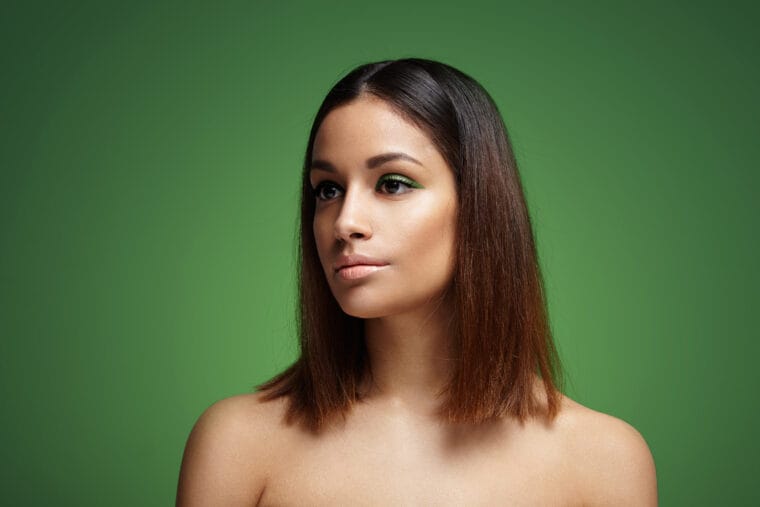 spanish woman with a green eye makeup on a green backgrond
